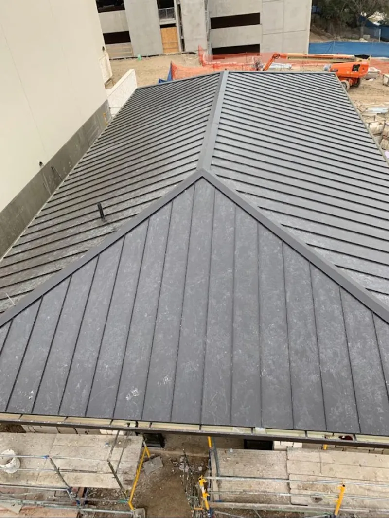 Commercial metal roof construction with crane equipment in Molalla